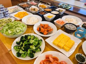 a table topped with plates of vegetables and other foods at Kuji Grand Hotel in Kuji +6 photos