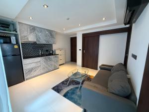 a living room with a couch and a kitchen at 2 BEDrooms with coffee machine,gym,rooftop pool in North Pattaya
