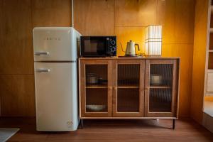a refrigerator next to a cabinet with a microwave at On Stay - Hotel Quality Stay in Seoul