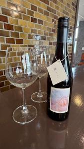 a bottle of wine sitting on a table with two wine glasses at hostel大黒屋 in Miyoshi