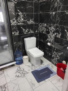 a bathroom with a toilet and a black tiled wall at Hostel in Yakuplu +21 photos