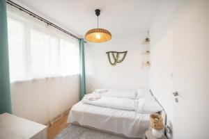 a white bedroom with a bed and a window at Boho Spa Apartments with Sauna in Sofia
