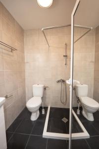 a bathroom with two toilets and a shower at Boho Spa Apartments with Sauna in Sofia