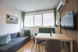 a living room with a couch and a table at Boho Spa Apartments with Sauna in Sofia