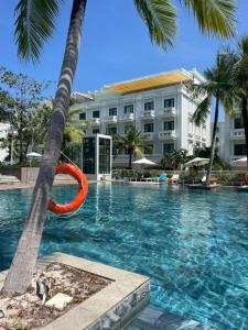 a swimming pool with a red life ring in front of a hotel at Cybade Hôtel in Phú Quốc