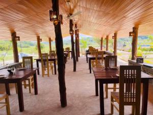 a restaurant with wooden tables and chairs and a ceiling at The Lark Resort ,induruwa in Induruwa