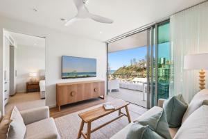 a living room with a couch and a tv at Miles at Kirra Point 604 in Gold Coast