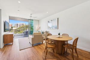 a living room with a table and chairs and a couch at Miles at Kirra Point 604 in Gold Coast