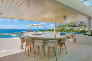 an outdoor patio with a table and chairs and the ocean at Miles at Kirra Point 604 in Gold Coast