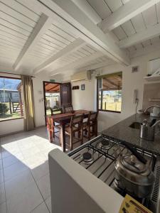 a kitchen with a stove and a table with chairs at Entre Montañas in Tafí del Valle