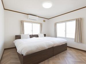 a bedroom with a large bed with two windows at Slow Toya in Lake Toya