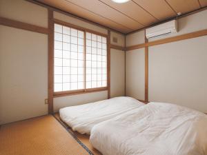 a bedroom with a white bed and two windows at Slow Toya in Lake Toya +46 photos