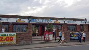 a group of people walking in front of a restaurant at Beachside Ingoldmells, 2 bedroom, Wifi in Ingoldmells