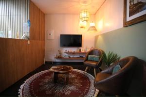 a living room with two chairs and a tv at Na Casa Hostel in Manaus