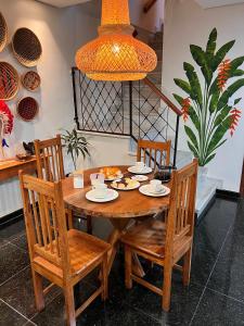 a dining room table with chairs and aendant light at Na Casa Hostel in Manaus