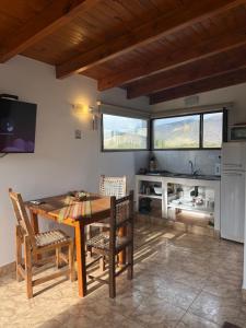 a dining room with a table and chairs and a kitchen at Entre Montañas in Tafí del Valle +54 photos