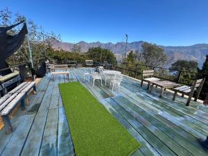 a wooden deck with a table and chairs on it at Mansión Del Arco in San Pedro La Laguna
