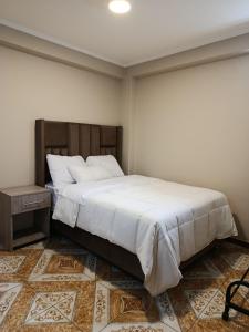 a bedroom with a large bed and a table at Allin Samay in Ayacucho