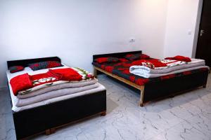 two beds sitting next to each other in a room at Aakarsh Hotel in Rudraprayāg