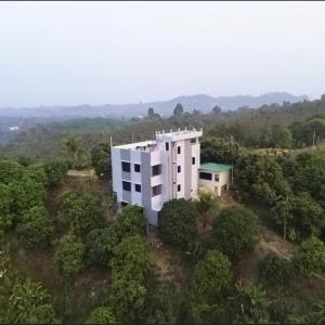 an aerial view of a white building in the forest at Sky n Valley in Bāndarban +5 photos