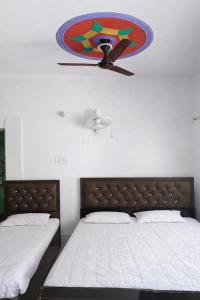 a bedroom with two beds and a painting on the wall at Aakarsh Hotel in Rudraprayāg
