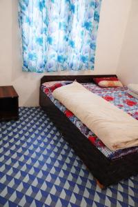 a bedroom with a bed and a table on the floor at Aakarsh Hotel in Rudraprayāg