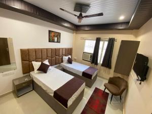 a hotel room with two beds and a television at Rudravasa Inn in Varanasi