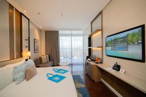 ein Hotelzimmer mit Bett und Flachbildfernseher in der Unterkunft Discovery Samal in Samal