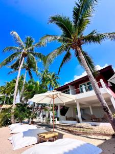 ein Gebäude am Strand mit Palmen und einem Sonnenschirm in der Unterkunft SOLEA Beach in Nathon Bay