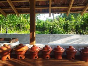 a row of clay pots sitting on a porch at Ovis kitchen in Matara