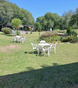 a group of white tables and chairs in a field at Del carmen chica in Villa Giardino +6 photos