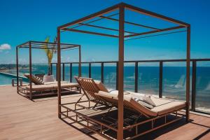 two lounge chairs on a deck with a view of the ocean at Art Studio Mare Loft in Salvador