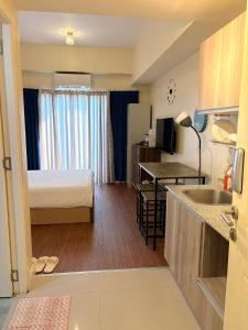 a small hotel room with a bed and a kitchen at Arlowes at 20f Grand Residences Cebu in Cebu City