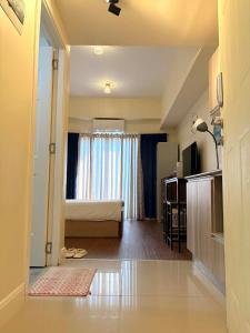 a living room with a bed and a window at Arlowes at 20f Grand Residences Cebu in Cebu City