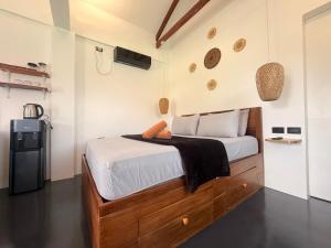 a bedroom with a bed and a small refrigerator at New Apartment Santa Fe in General Luna