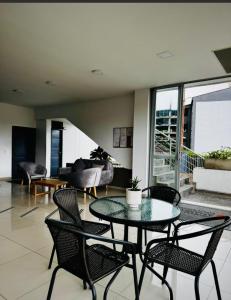 a room with a table and chairs and a living room at Apartamento de 3 habitaciones al Norte de Armenia - excelente ubicación - parqueadero privado in Armenia