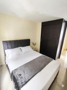 a bedroom with a large bed with a black door at Apartamento de 3 habitaciones al Norte de Armenia - excelente ubicación - parqueadero privado in Armenia