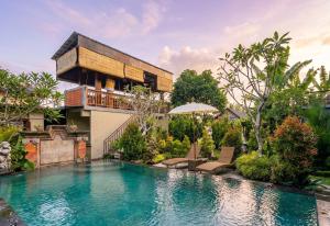a house with a swimming pool in front of a building at Sari Murni in Ubud