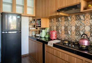 a kitchen with wooden cabinets and a black counter top at Sari Murni in Ubud