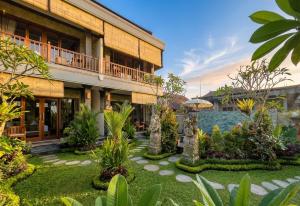 a resort with a garden in front of a building at Sari Murni in Ubud