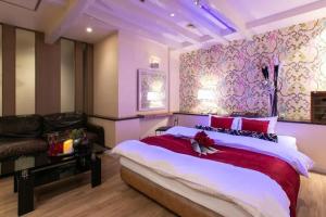 a bedroom with a large bed and a couch at HOTEL SWING - Couple's Hotel in Beppu