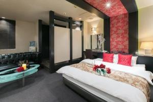 a large bedroom with a large bed with red pillows at HOTEL SWING - Couple's Hotel in Beppu