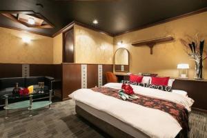 a hotel room with a large bed and a desk at HOTEL SWING - Couple's Hotel in Beppu