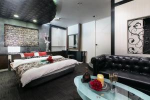 a bedroom with a large bed and a couch at HOTEL SWING - Couple's Hotel in Beppu