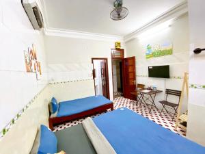 a room with a bed and a table and a tv at DK House Homestay in Hoi An