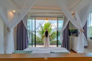 a woman in a wedding dress is standing on a bed at The Cozy Beachfront Phuket in Patong Beach