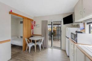 a kitchen with a table and chairs in a room at Reflections Coffs Harbour - Holiday Park in Coffs Harbour