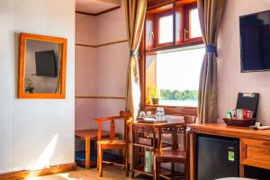 a living room with a table and a window at Nhật Tín Hotel in Kinh Dinh