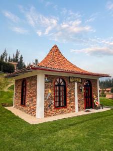 a small brick building with a red roof at La Casita de Carpintero in Cucunubá