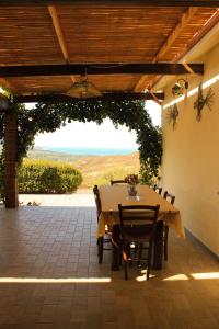 eine Terrasse mit einem Tisch und Stühlen unter einer Pergola in der Unterkunft Fighezia in Fluminimaggiore